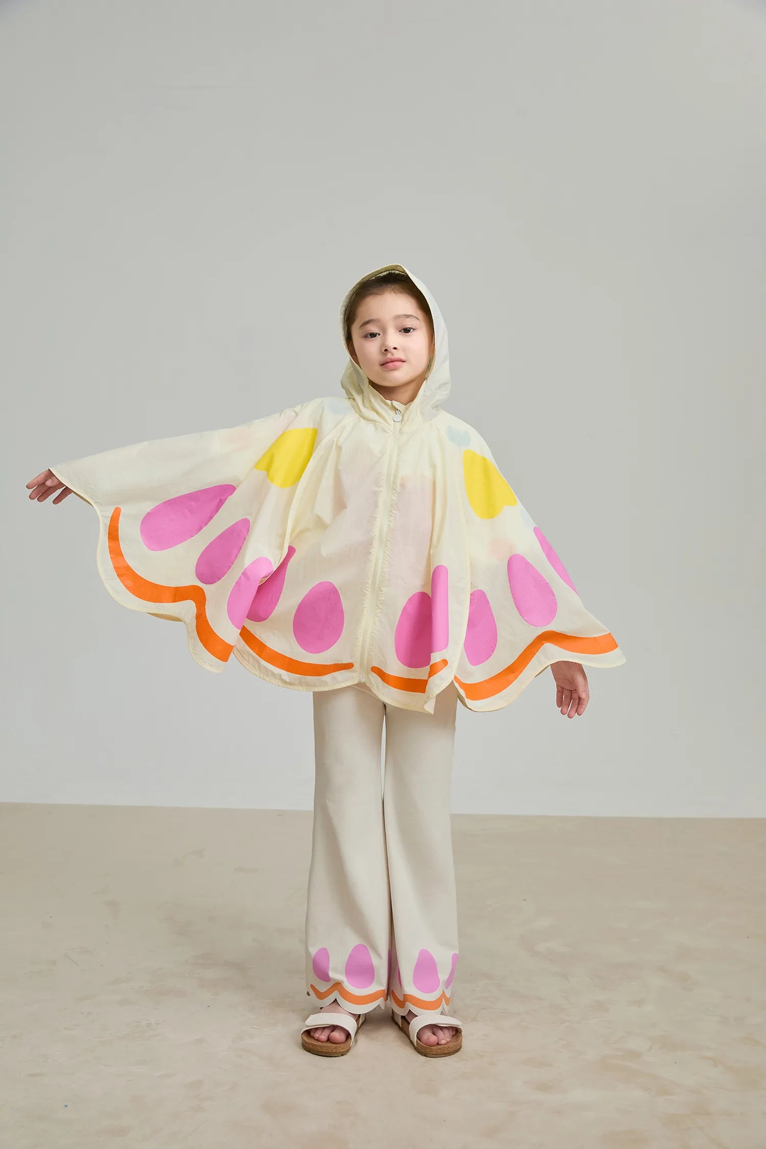Girl wearing the Poco Blush SS25 Butterfly Cape Lightweight Hooded Jacket