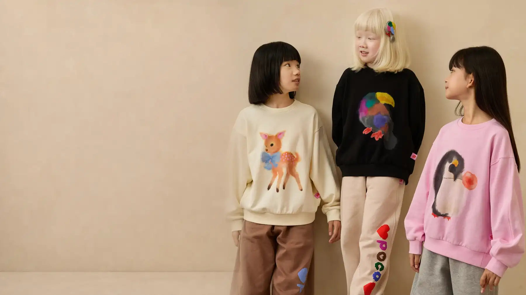 Three children wearing Poco Blush Ink-Wash Animals sweatshirts