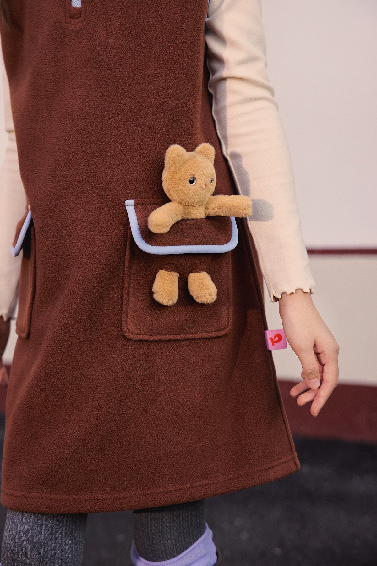 Ink-Wash Animal-Pocket Fleece Pinafore — Caramel Brown; worn view; other styled garments and accessories are not included